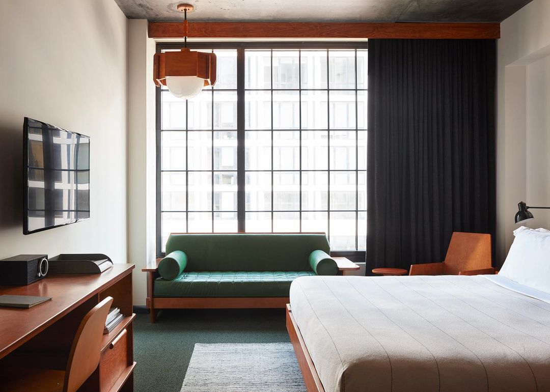 A room with city views featuring a desk, chair and sofa for seating
