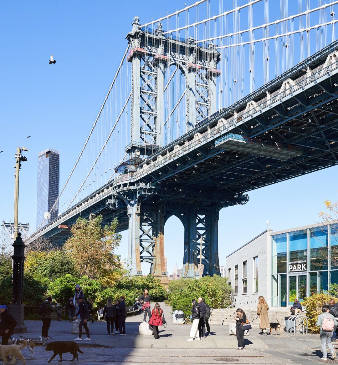 Brooklyn bridge in the daytime and people walking underneath