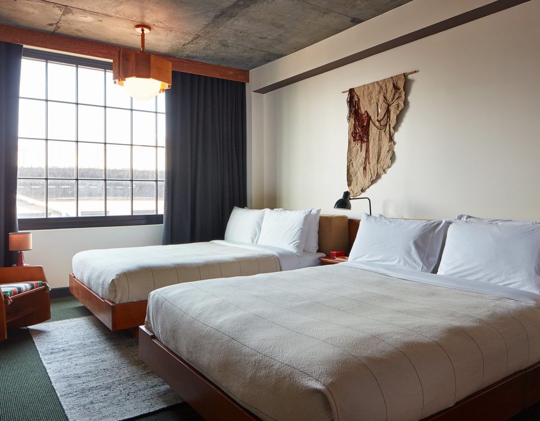 A room with modern styling and hanging light fixture suspended from a concrete ceiling