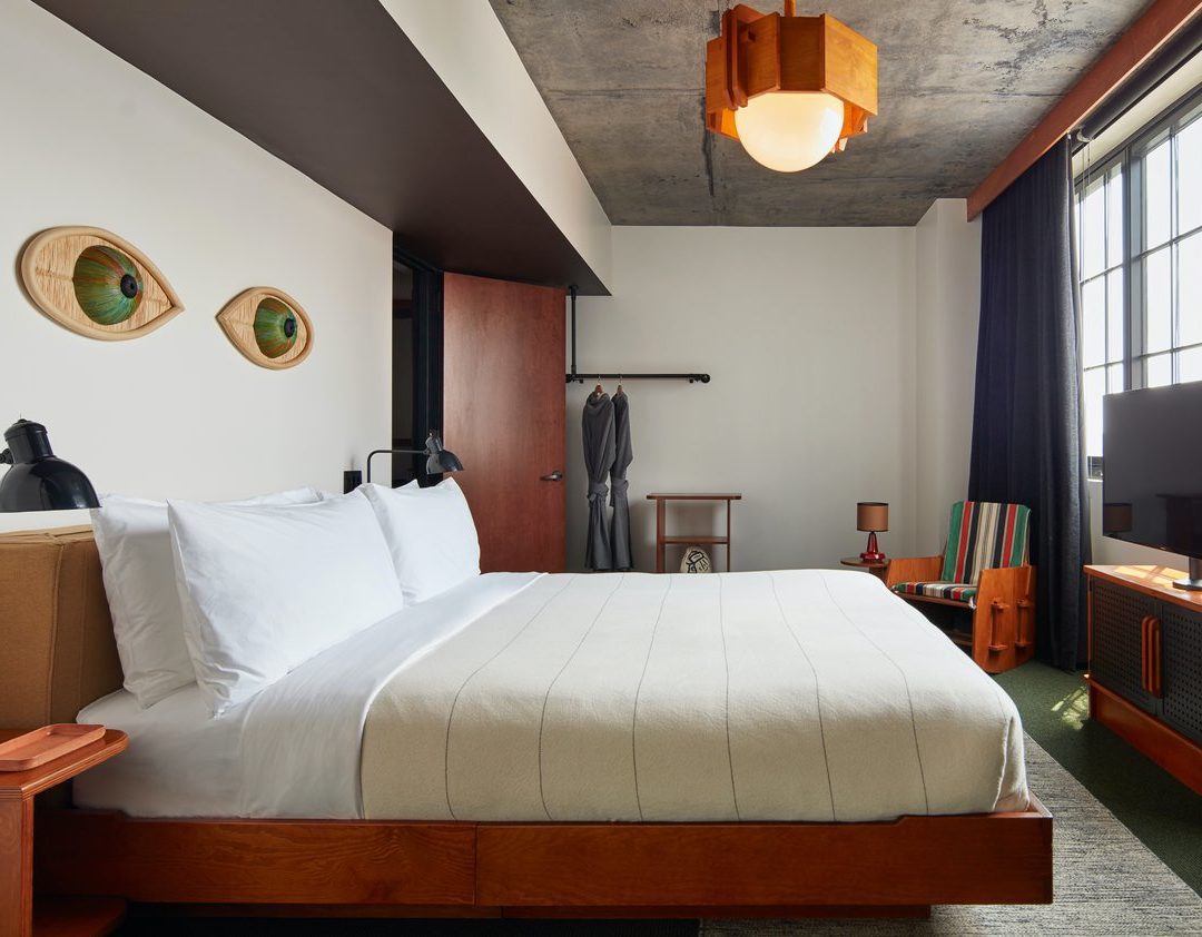 A dedicated bedroom with modern decor, a bar for hanging clothes and multiple light sources