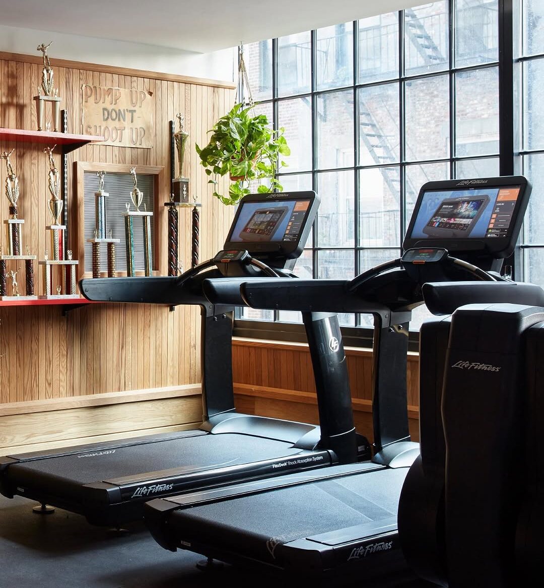 a photo of a gym with equipment that includes treadmills. And a sign that reads, 
