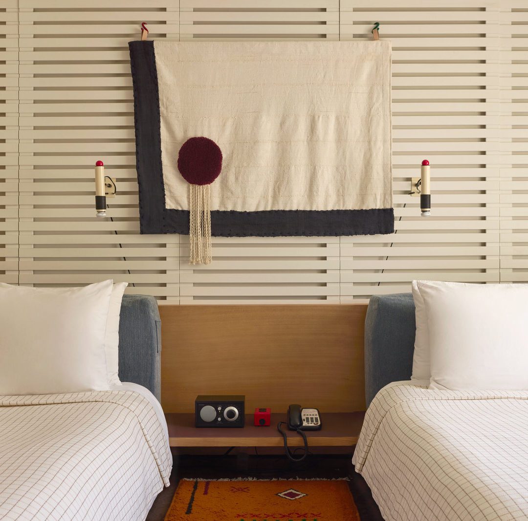 A bluetooth radio and phone sit between two beds