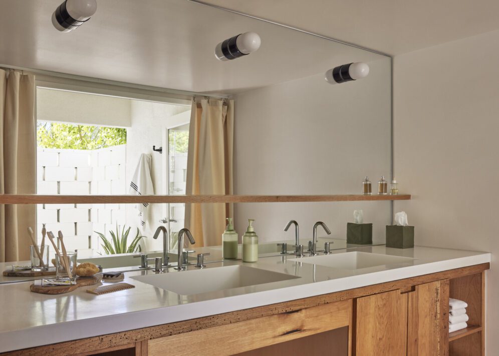 A modern bathroom featuring two sinks and a large mirror above them, reflecting the stylish decor
